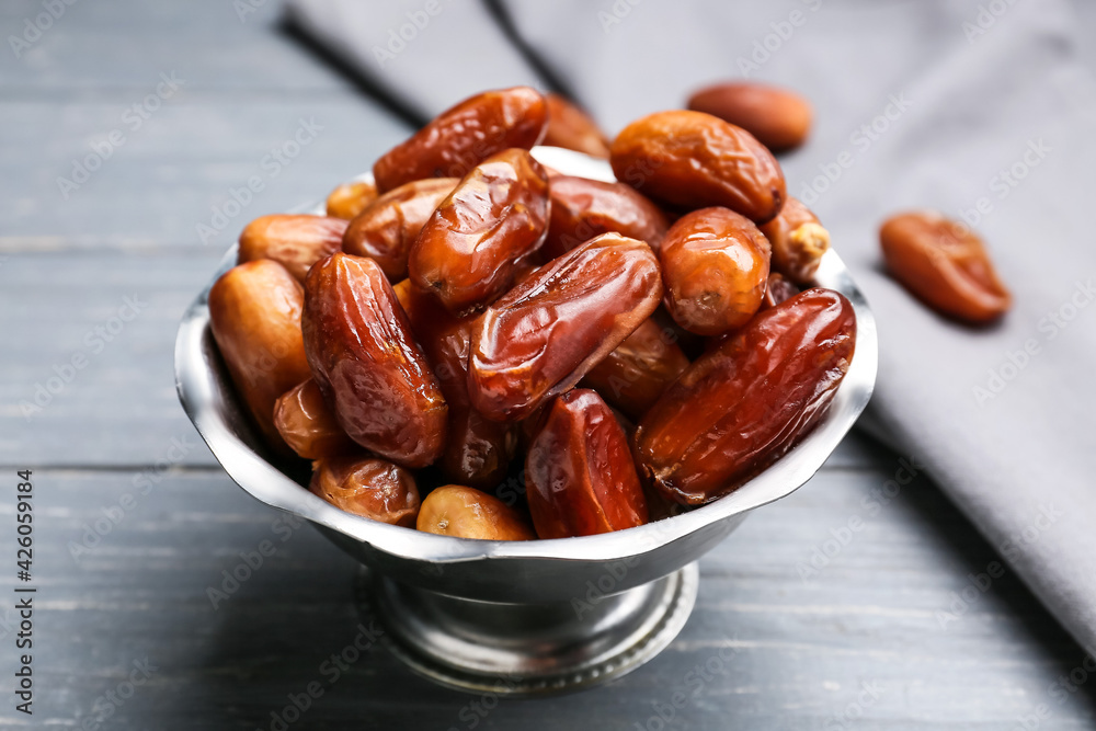 Bowl with sweet dried dates on dark wooden background, closeup Bowl with sweet dried dates on dark wooden background, closeup