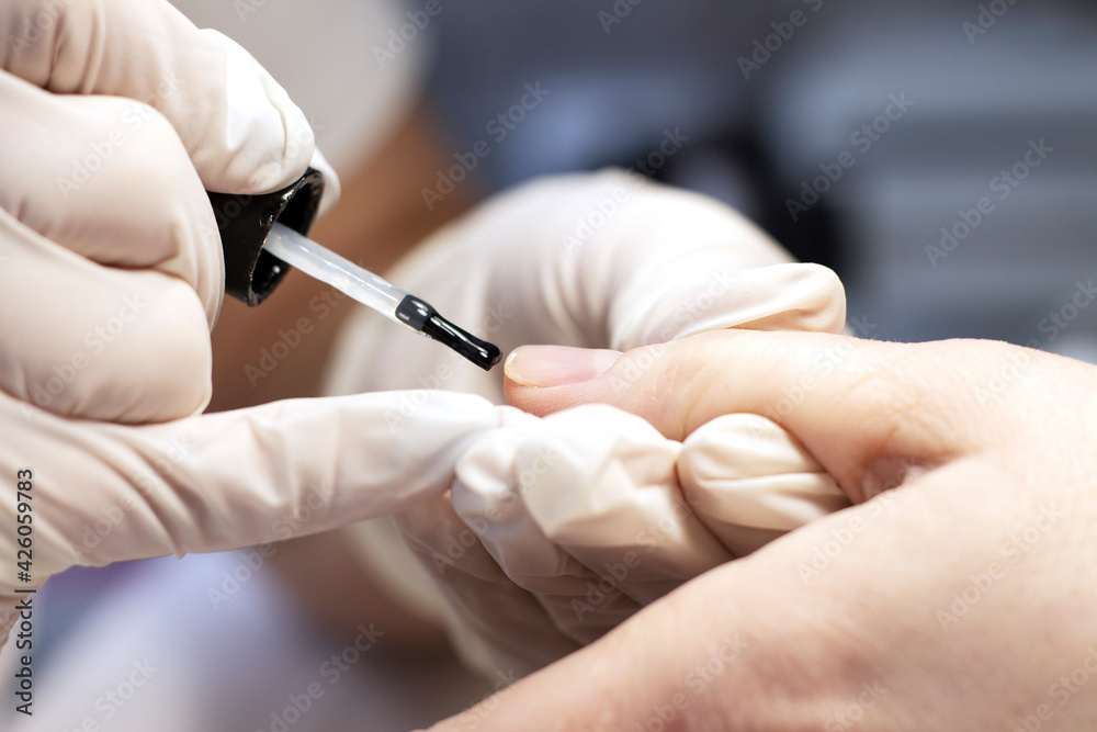 Manicure coating of nails on women's hands with gel polish in a beauty salon by a specialist. Close-up. Space for text Manicure coating of nails on women's hands with gel polish in a beauty salon by a specialist. Close-up. Space for text
