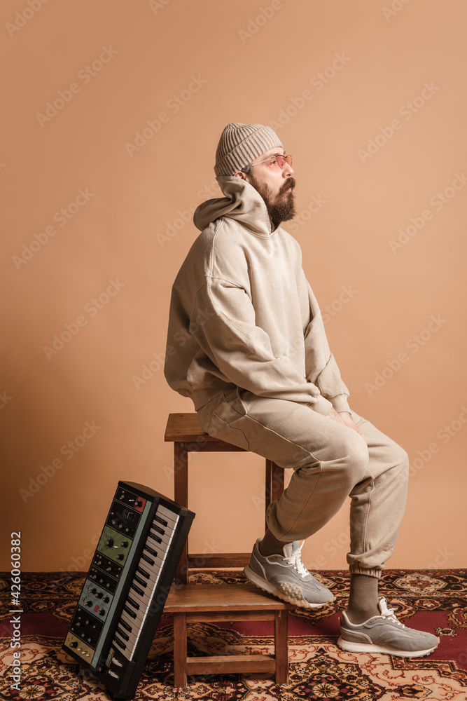 Fototapeta premium Full-length portrait of man, musician isolated on light yellow background.