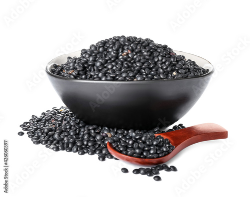 Bowl and spoon with black lentils on white background