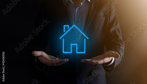 Real estate concept  businessman holding a house icon.House on Hand.Property insurance and security concept. Protecting gesture of man and symbol of house.