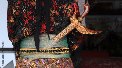 Men wearing traditional Javanese attire with keris. Keris is a traditional Javanese weapon. With black background photo