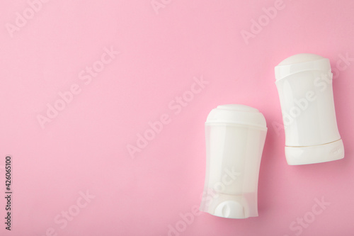 White antiperspirant deodorant on pink background. Skin care concept. copy space, top view