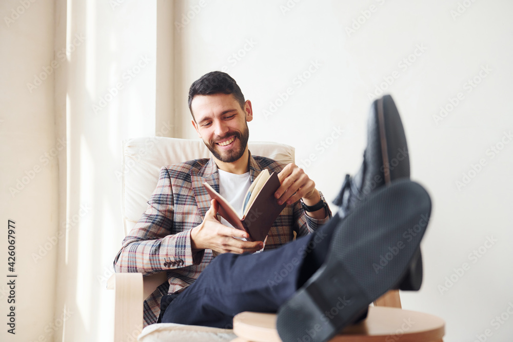 Reads book. Young stylish businessman in suit indoors. Conception of success Reads book. Young stylish businessman in suit indoors. Conception of success