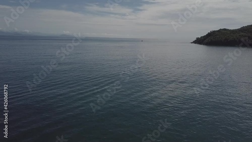 Ilha no mar e barco distante