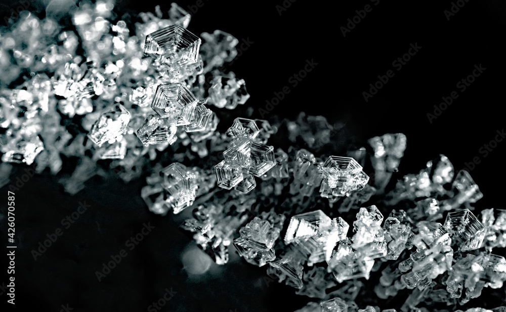 Naklejka premium Natural ice crystals frostwork on black backround. Macro closeup.