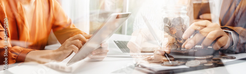 Business people use tablets and hold credit cards as an online shopping concept With a calculator and a book placed on the table