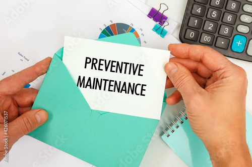 The businessman takes out a card from the envelope with the text Preventive Maintenance