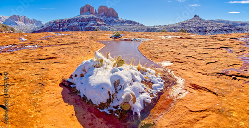 Snow covered Cathedral Rock in Sedona viewed from a sandstone plateau along Secret Slick Rock Trail, Arizona, United States of America photo