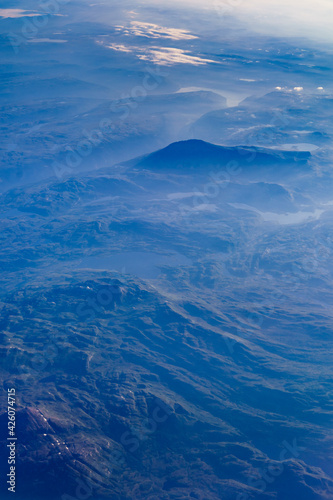 View from airplane to clouds and land