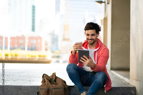 Young man using digital tablet outdoors.
