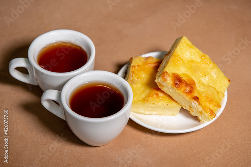 Two cups with tea, cottage cheese casserole on a saucer. Breakfast. Close-up. Selective focus.