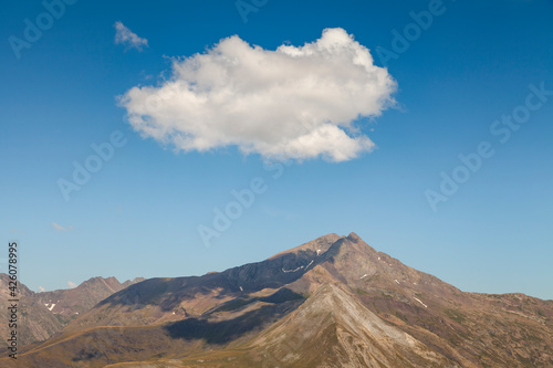 Landscape photography of steep mountains in summer  lonely clouds  and silent high altitude pastures  in the Aragonese Pyrenees  Huesca province  in the area of the Posets-Maladeta Natural Park.