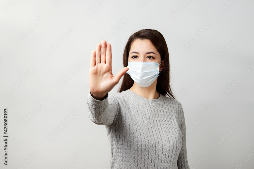 Young woman wearing medical mask, white background. Young woman wearing medical mask, white background.