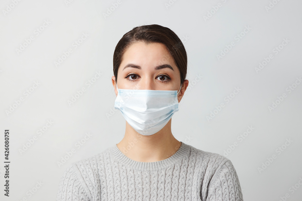 Young woman wearing medical mask, white background. Young woman wearing medical mask, white background.