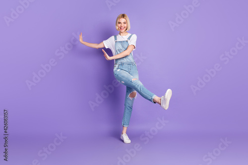 Full size photo of nice optimistic short hairdo blond lady dance wear white t-shirt overall isolated on violet background