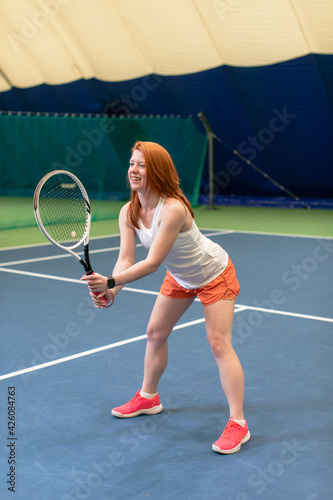 Female tennis player concentrated on game. Woman waits for the pitch to hit the ball back