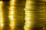 Group of golden coin stacking in vertical row shallow focus with fill in frame with gold coin blur background, rows of coins for finance and banking. finance and business concept.