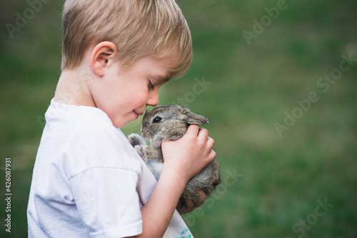 Wallpaper Mural Small boy with his furry friend little rabbit. Kid and animal care concept with copy space. Torontodigital.ca