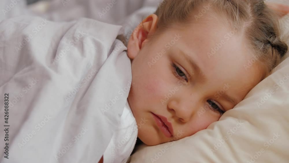 Portrait of sick little girl lying on bad, cold flu virus disease concept Portrait of sick little girl lying on bad, cold flu virus disease concept