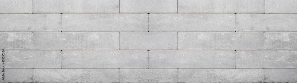Naklejka premium Gray retaining wall garden from concrete shuttering blocks masonry brickwork wall texture banner panorama