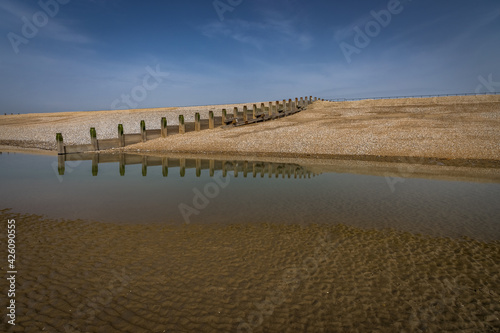 Reflections of groynes on the beach at Camber, East Sussex, England