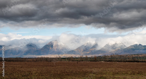 Eastern Sayans in autumn. Snow-capped peaks of Tunkinskiye Goltsy ridge.