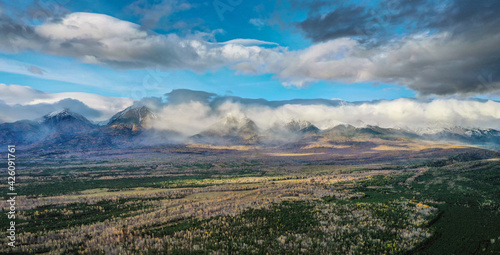 Eastern Sayans in autumn. Snow-capped peaks of Tunkinskiye Goltsy ridge. Aerial view.