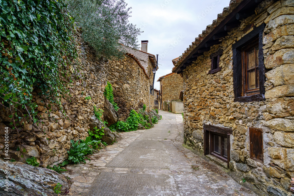 Narrow alley in an old medieval town made of stone in the Sierra de Madrid. Horcajuelo.
