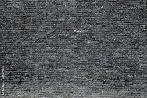 Old Black Brick wall is a block texture background for design and decoration.