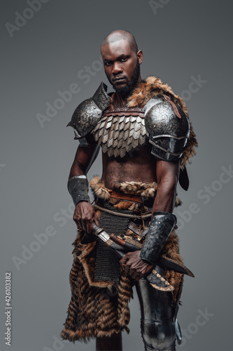 Wild ancient soldier with shaved head and black skin with a blade