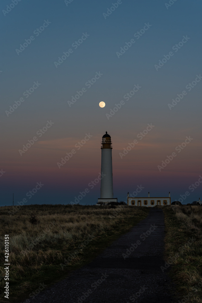 lighthouse at dusk with full moon
