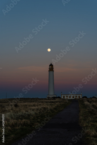 lighthouse at dusk with full moon