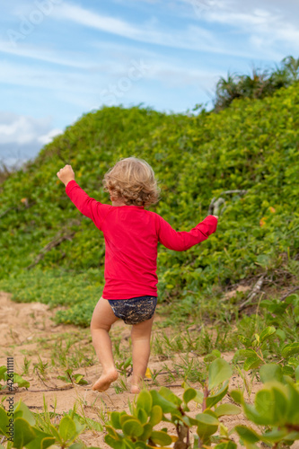 child playing on the beach vegetation
