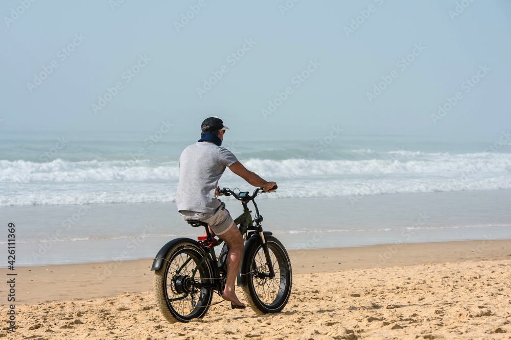 Fototapeta premium man doing fat bike on the beach