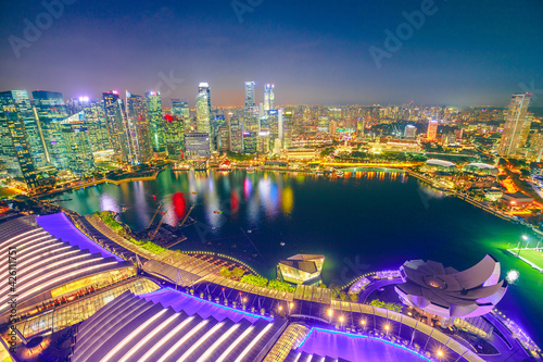 Singapore - May 3, 2018: Aerial view of Singapore Marina Bay with Financial District skyscrapers illuminated at night reflected on the harbor. Rooftop above Singapore skyline. Night urban scene.