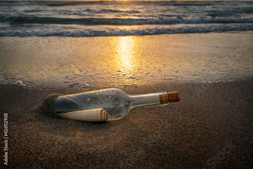 United States, Florida, Boca Raton, Glass bottle with message inside on beach at sunset