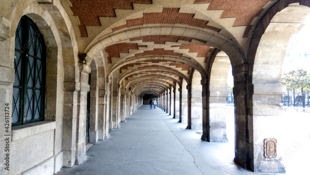 Fototapeta premium Beautiful archway in the old town country. Young people walking in historic place.