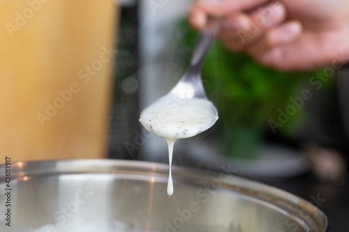 Bechamel sauce dripping from the kitchen spoon