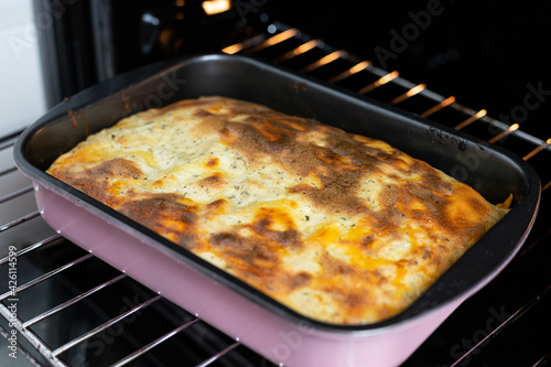 Lasagne in a baking tin, taken from the oven. Preparation of a traditional Italian dish.