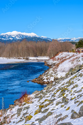 Fototapeta Naklejka Na Ścianę i Meble -  Majestic mountain river in winter over snow mountains and blue sky in Vancouver, Canada.