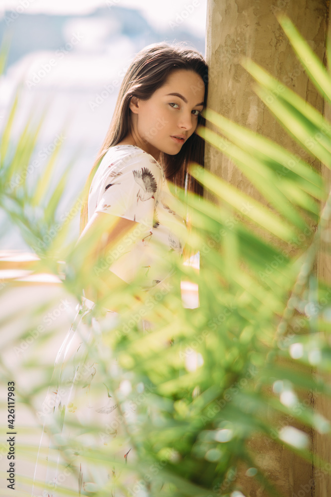 Portrait of woman by the wall near houseplants. Portrait of woman by the wall near houseplants.