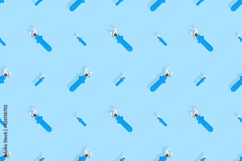 Background from a metal adjustable wrench with a rubber handle. Tools seamless pattern. Background from a metal adjustable wrench with a rubber handle. Tools seamless pattern.