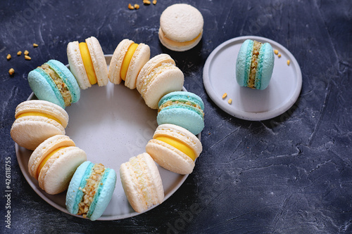 french dessert macaroons on a plate on grey background.turqiouse and beige macarons hand made. home bakery concept. sugar free baking photo