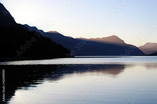 dusk over the lake shore with mountains background