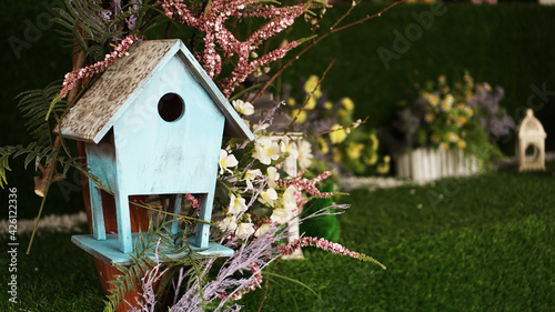 Decorative nesting boxes on bright background. Blue birdhouse on green background