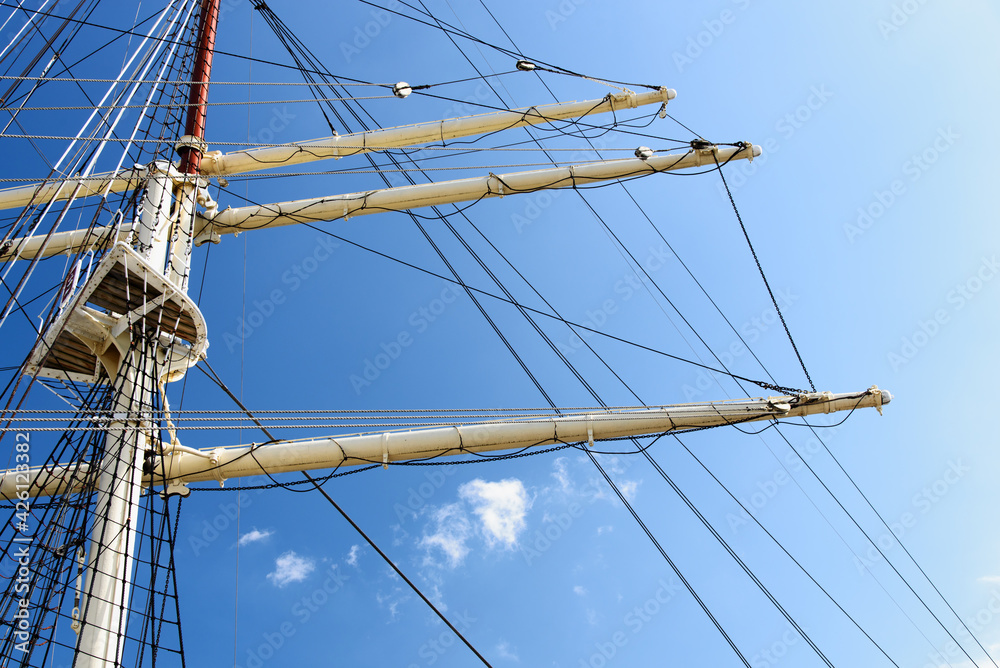 Details of the masts and rigging of the sailing ship against the blue sky in close-up Details of the masts and rigging of the sailing ship against the blue sky in close-up