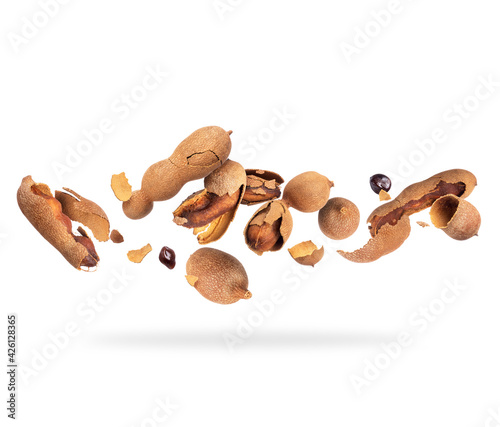 Crushed tamarind fruits in the air on white background