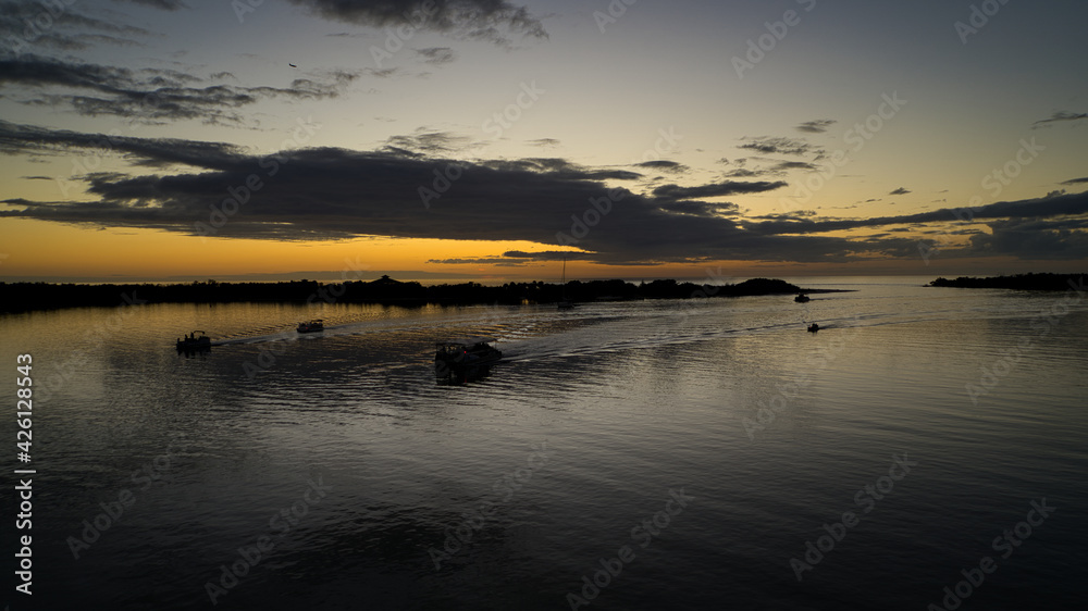 Romantischer Sonnenuntergang am Meer - Urlaubsfeeling und Romantik, während die Boote den Heimathafen anfahren