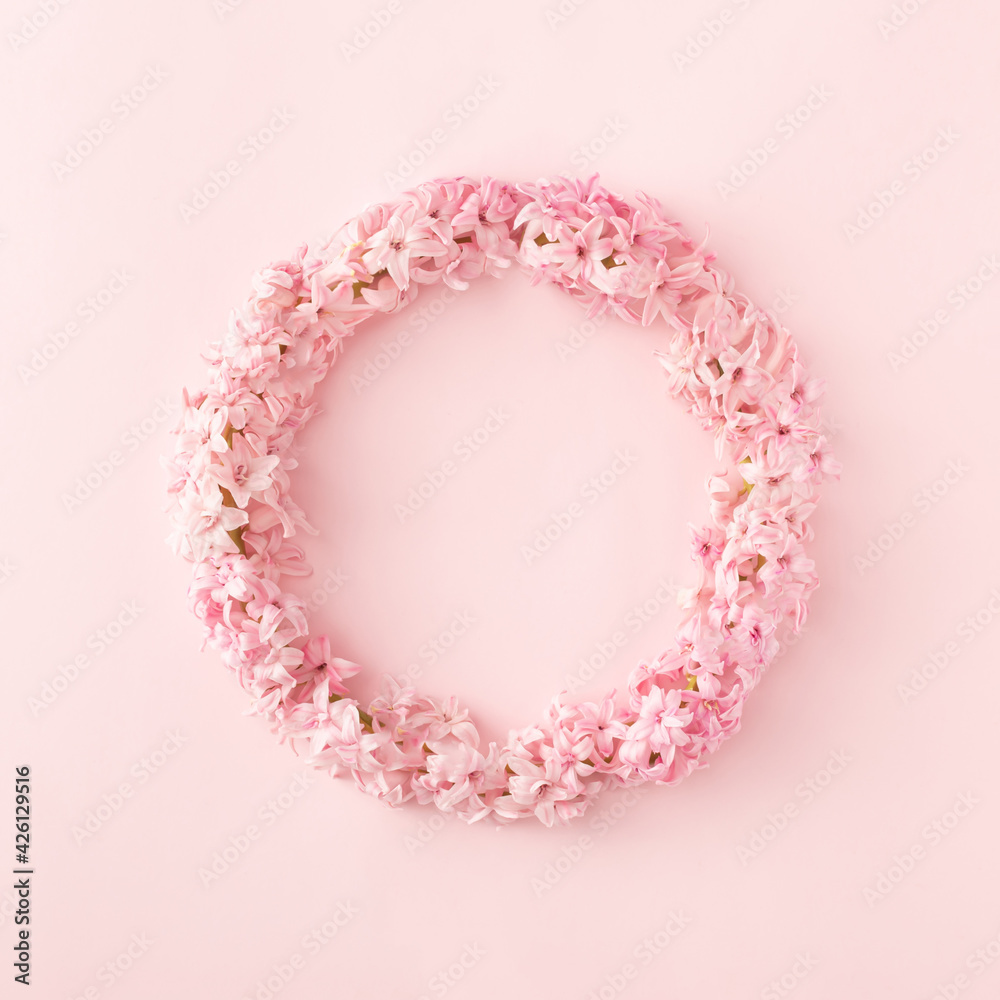 Round floral frame made of fresh lilac flowers on pastel pink background. Minimal spring concept.